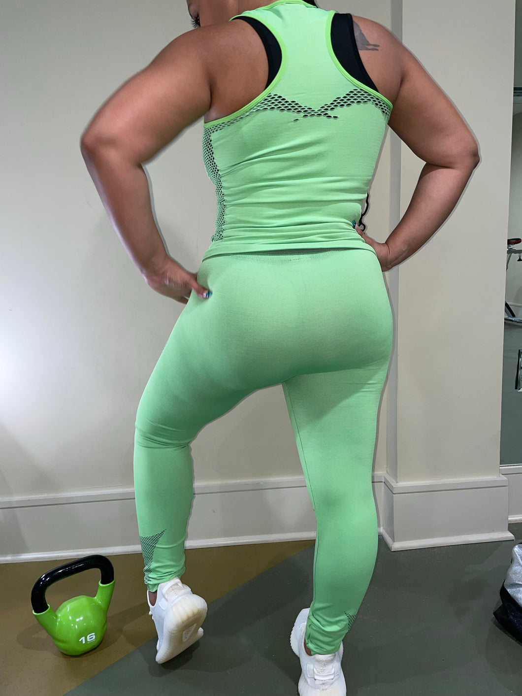 Woman wearing green yoga fitness set - matching sports bra and leggings.