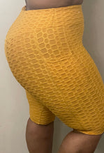 Load image into Gallery viewer, Right side of Yellow bubble shorts with pocket for women - versatile and comfortable activewear for workouts and everyday wear.
